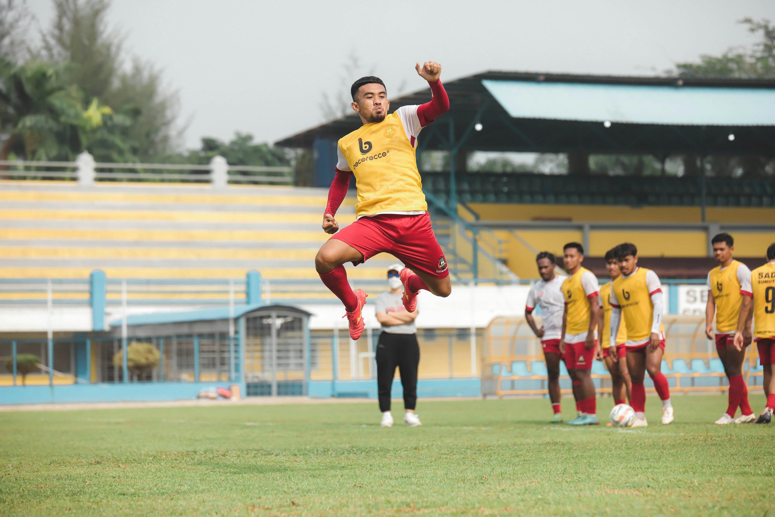 Soccer players practice on a vibrant field in Jakarta, showcasing athleticism and teamwork.