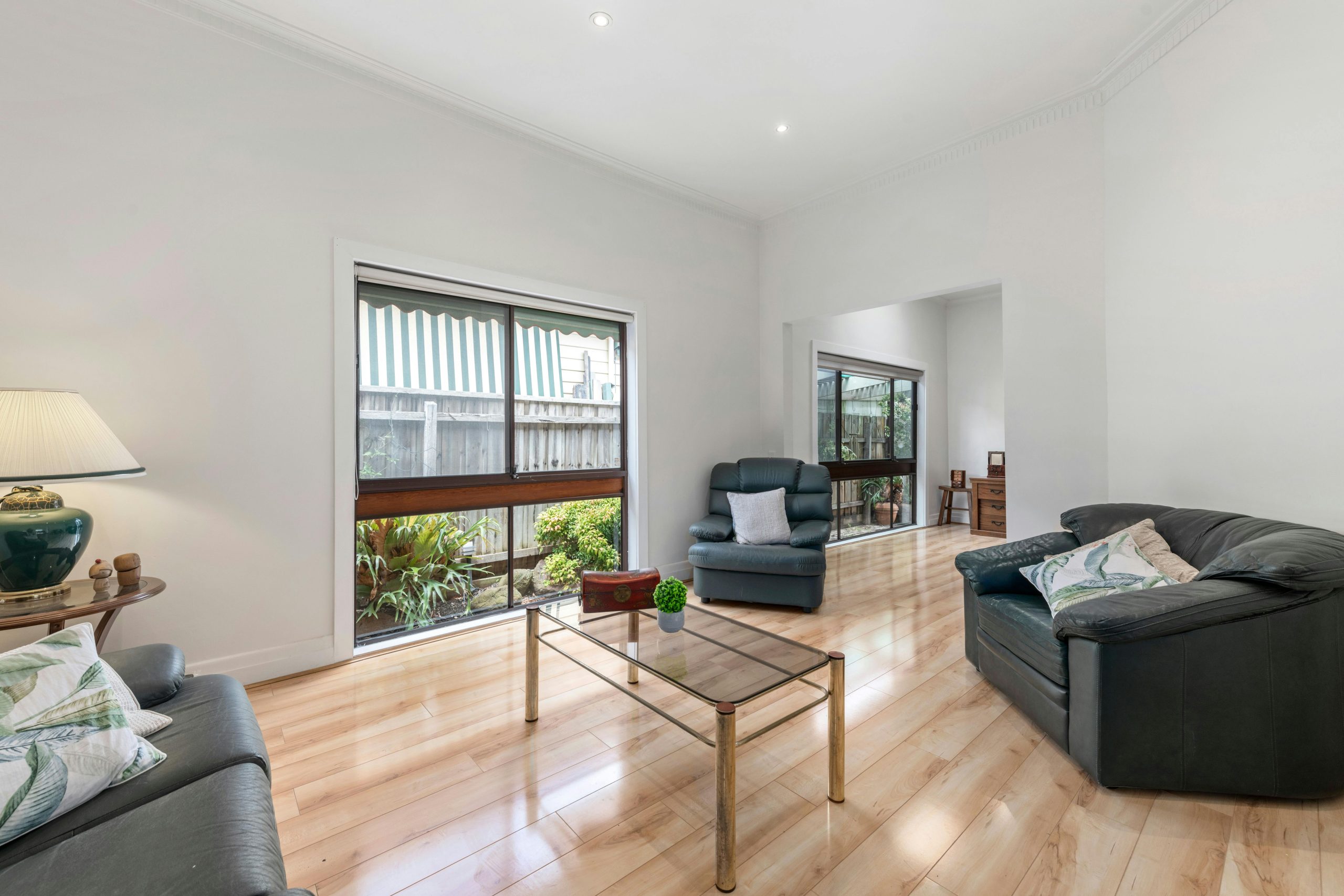 Bright living room with contemporary seating, wooden floors, and large windows letting in natural light.