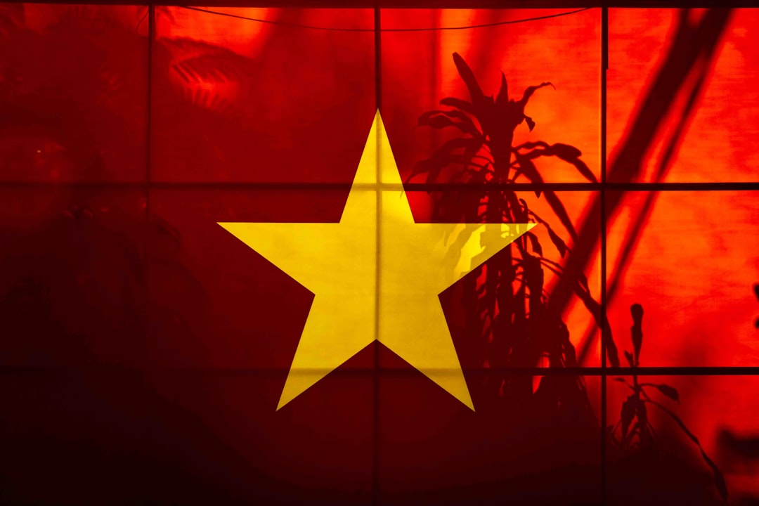 A yellow star on a red background with plant shadows
